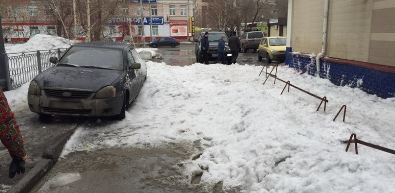 В Омске снег с крыши магазина рухнул на припаркованную машину