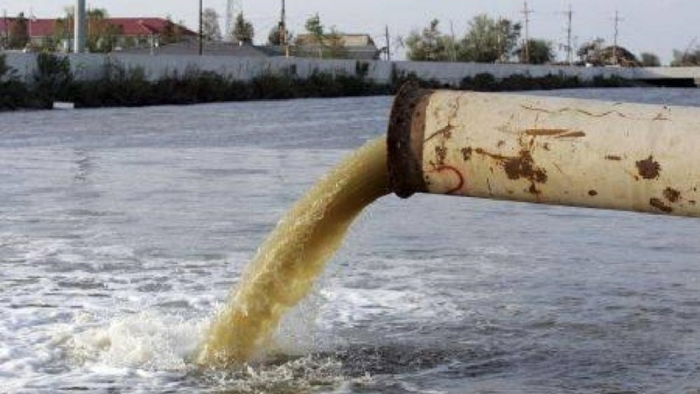 Сброс воды в водоем. Слив отходов в реку. Загрязнение воды промышленными отходами. Жидкие отходы. Труба слив отходов.